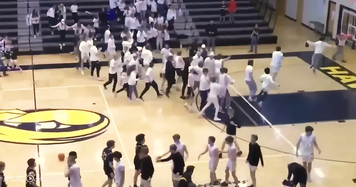 A group of people in white shirts and black pants are running on a basketball court.