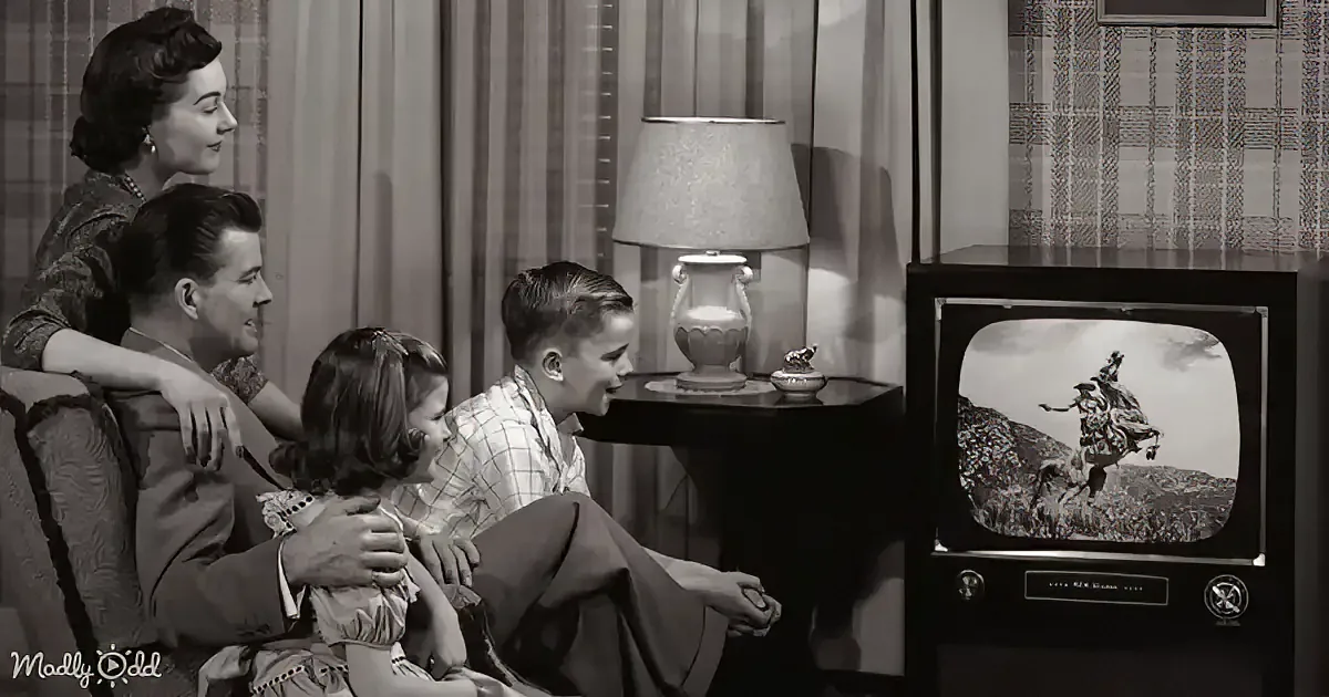 A family watches a cowboy on TV in a vintage living room.