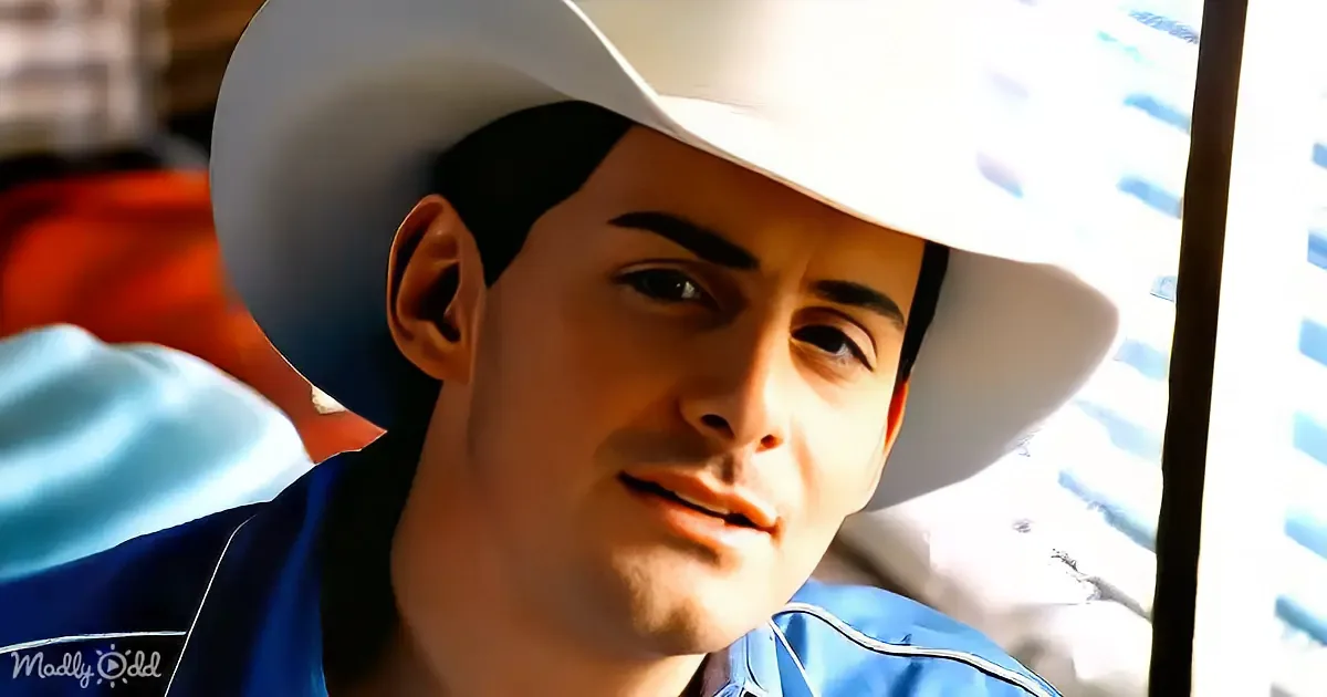 A man wearing a white cowboy hat and a blue shirt, looking to the side with sunlight shining on his face.