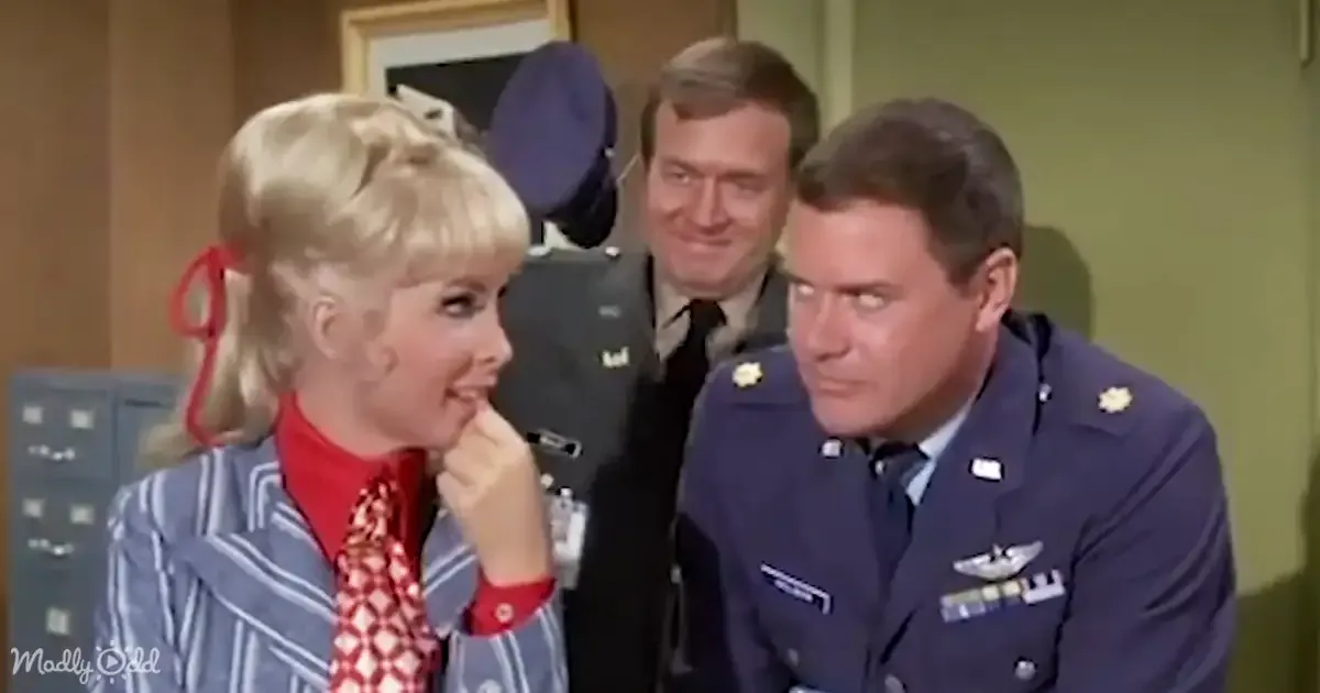 A woman in a striped blazer and red tie smiles while two men in military uniforms look on.