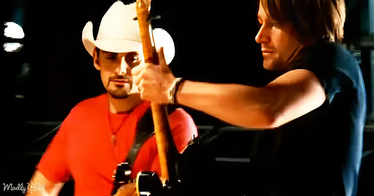 A man in a white cowboy hat holds a banjo, another man in an orange shirt plays a guitar in the background.