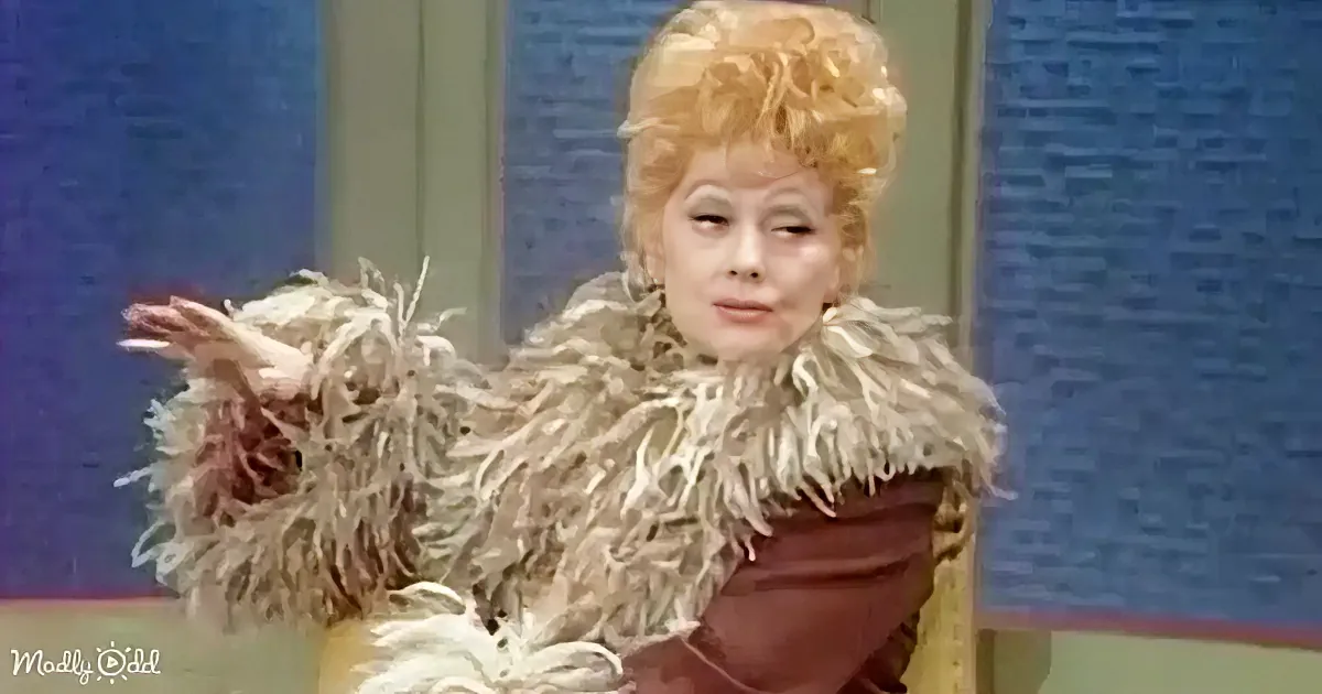 A person in a fur-trimmed outfit and elaborate hairstyle is gesturing with their hand.
