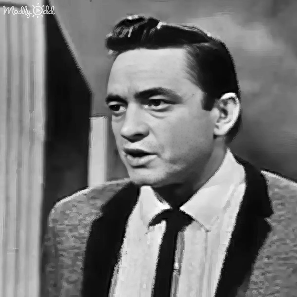 A man in a suit and tie, looking slightly to the side, with a vintage black-and-white aesthetic.