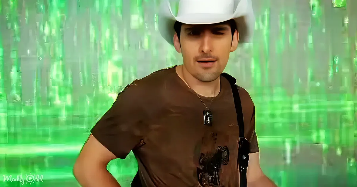 A man in a brown shirt and white cowboy hat stands against a green, pixelated background.