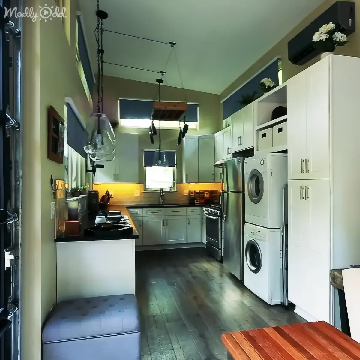 A modern kitchen with white cabinets, stainless steel appliances, and a cozy seating area.