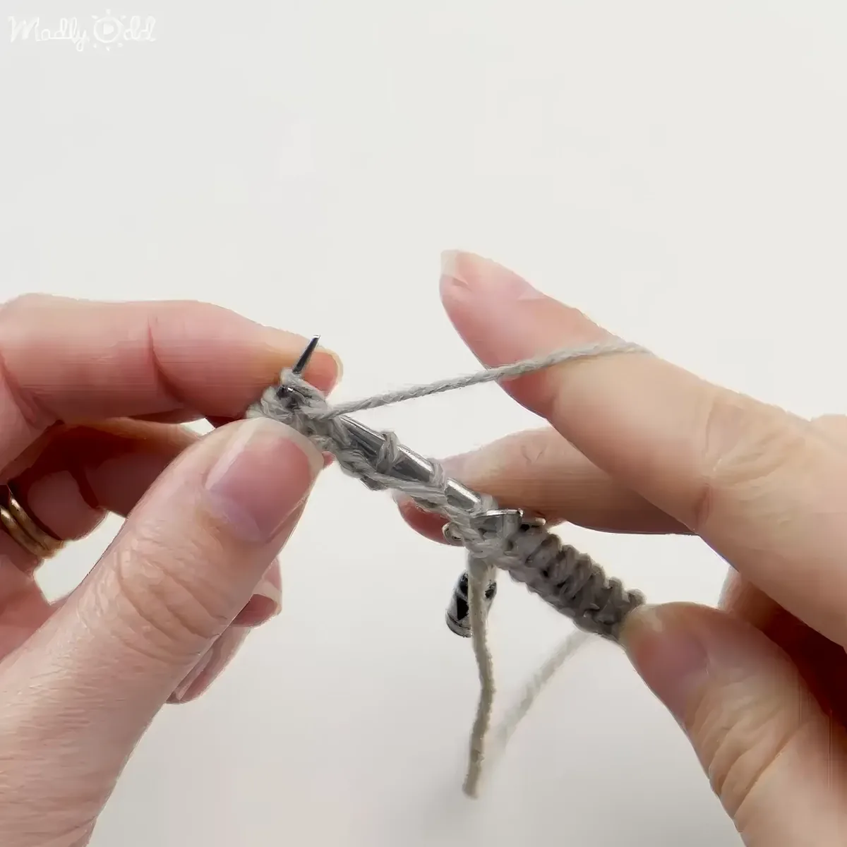 Instructor demonstrates knitting techniques on video