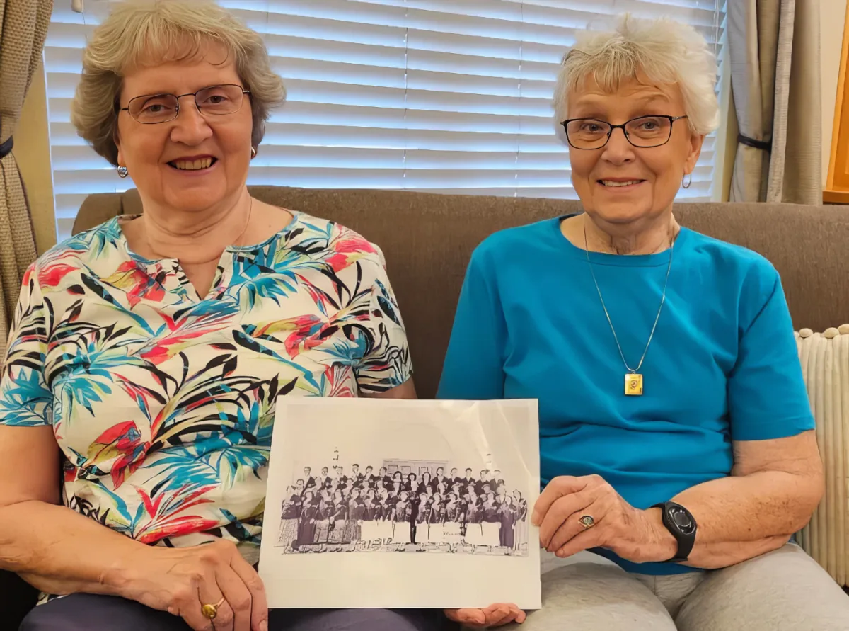 Two seniors holding a school photo
