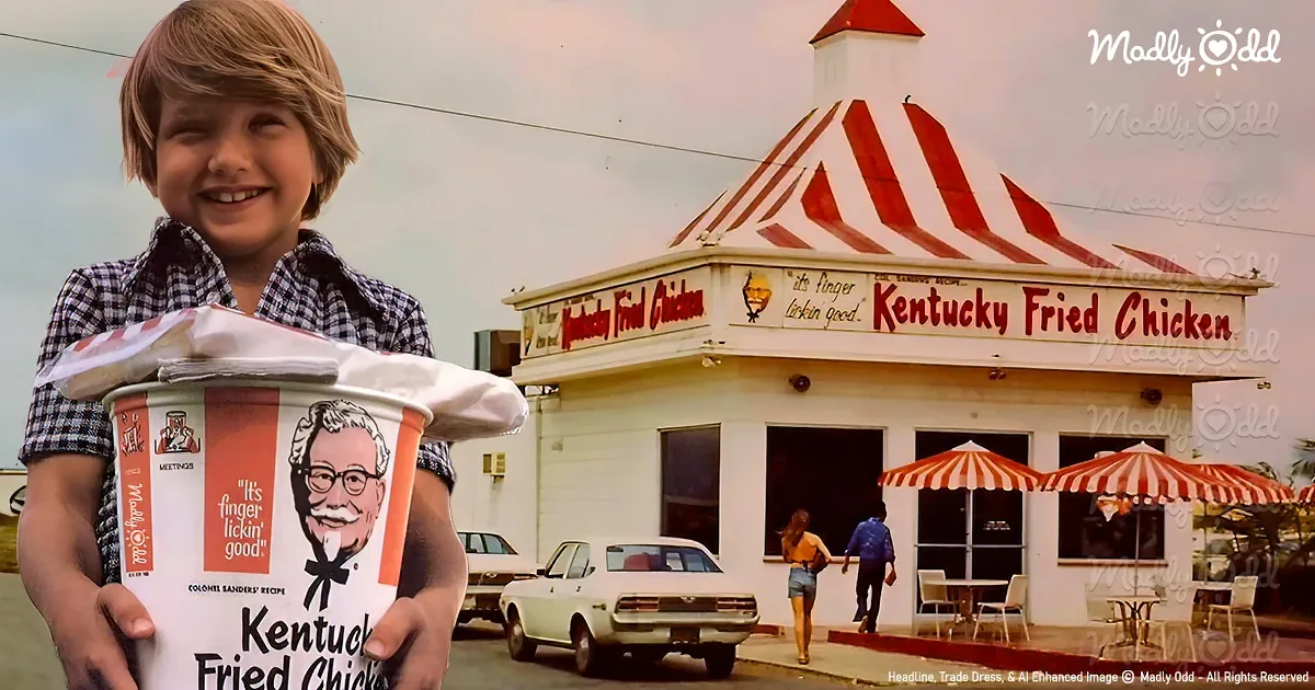 A young boy holds a large KFC bucket in front of a vintage Kentucky Fried Chicken restaurant.