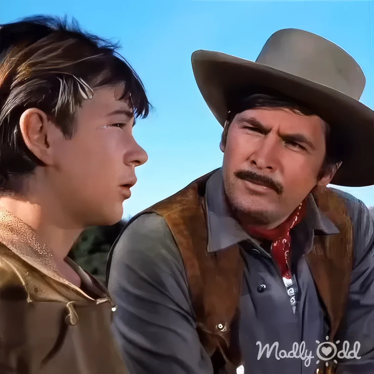 Father and son share emotional moment in Old Yeller's heartfelt scene, eyes filled with tears.