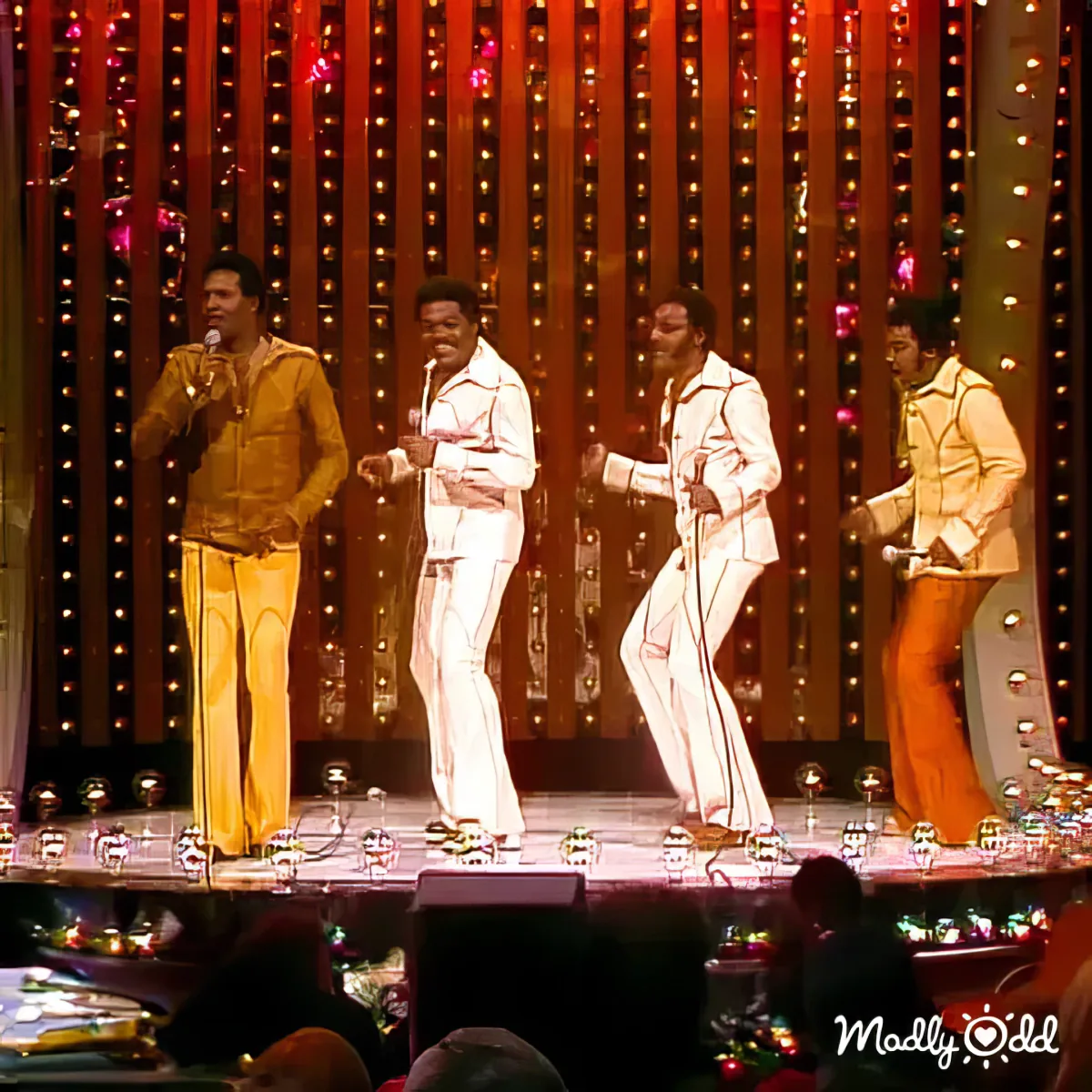 Motown classic love song performed on stage, singer holding microphone, band behind.