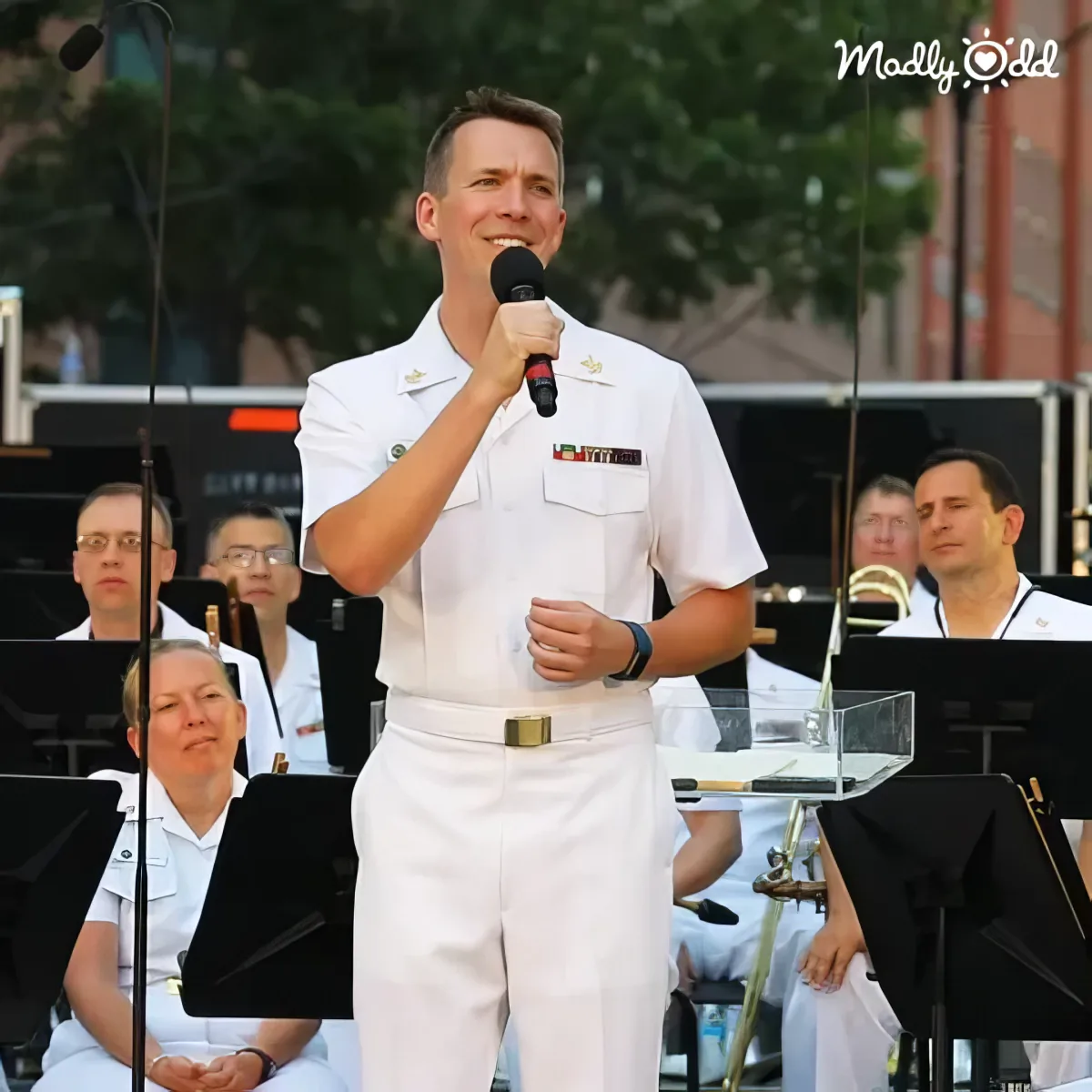 Navy Band performs 'Over the Rainbow,' sailors playing instruments, conductor leading.