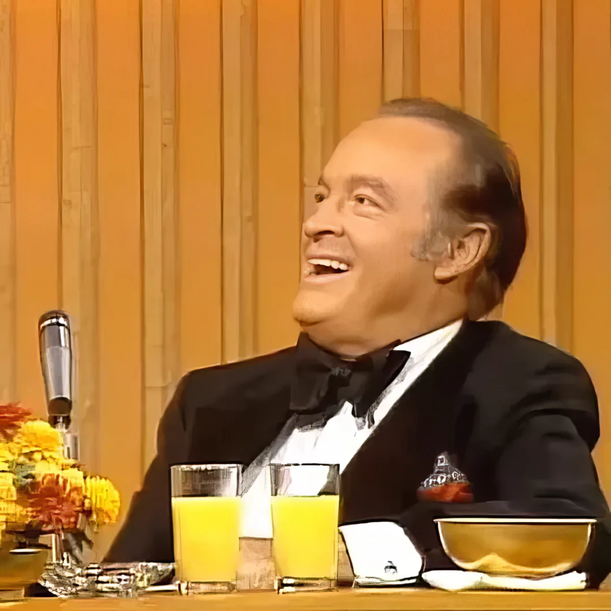 Foster Brooks jokes, Bob Hope laughing uncontrollably, wiping tears from eyes.