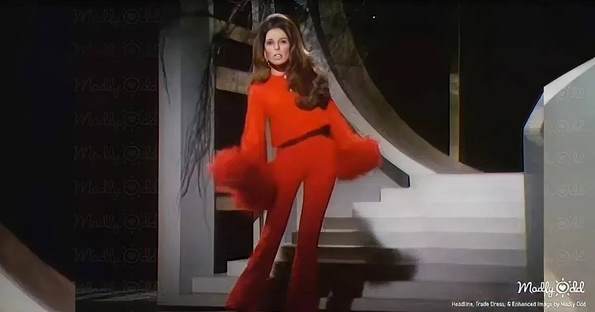 A woman in a bright red outfit stands on a staircase, holding her leg up, with a dark, shadowy background.
