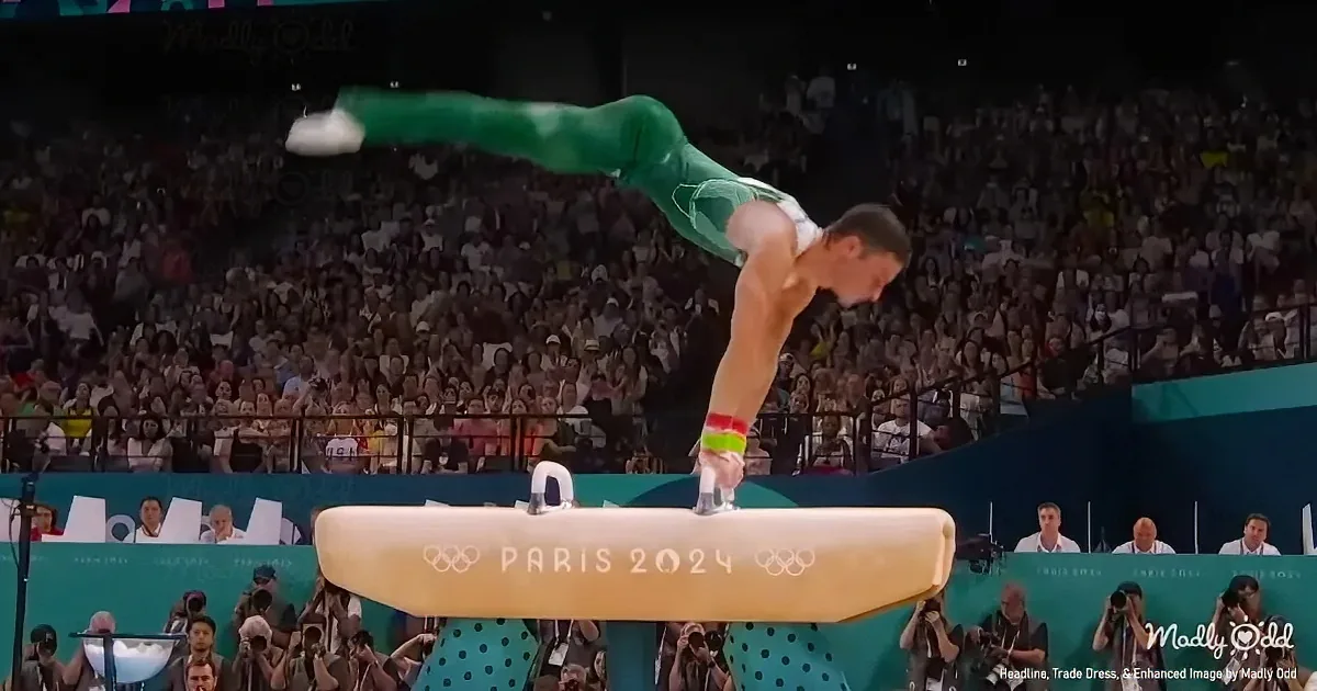 A gymnast in green performs a handstand on a pommel horse at the Paris 2024 Olympics.