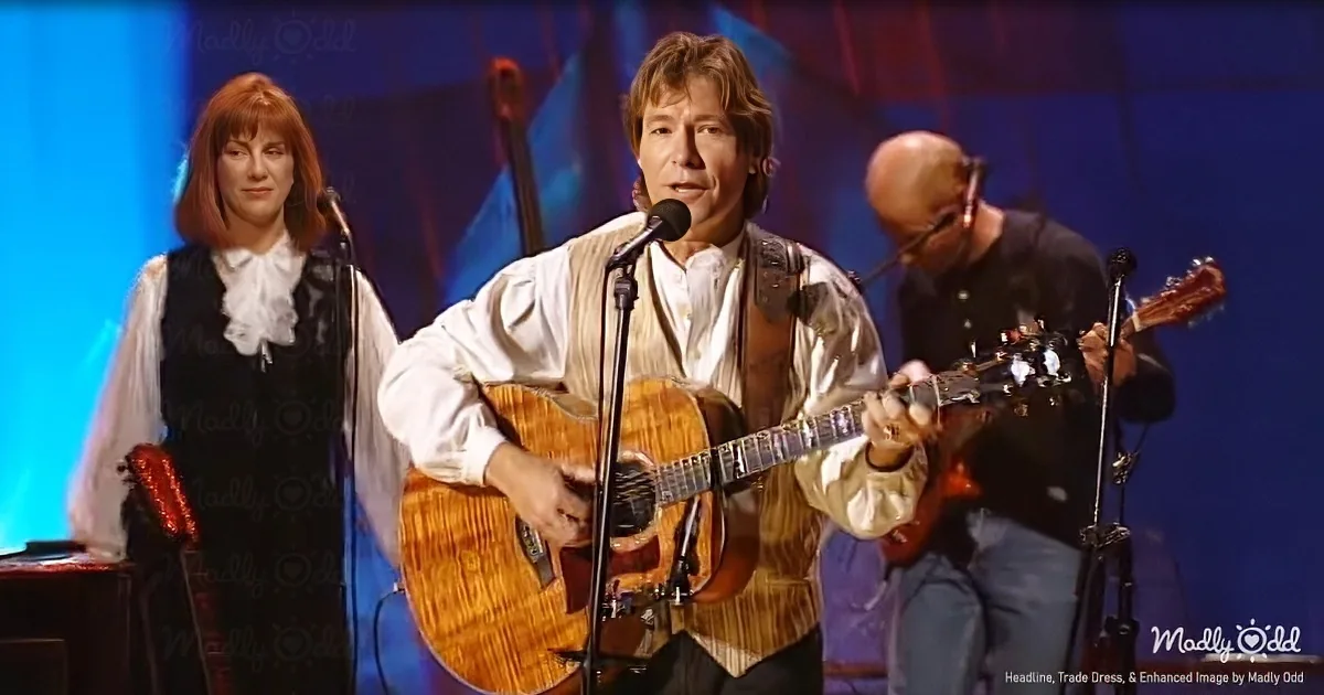 A man plays guitar and sings on stage with a band, wearing a white shirt and brown vest.
