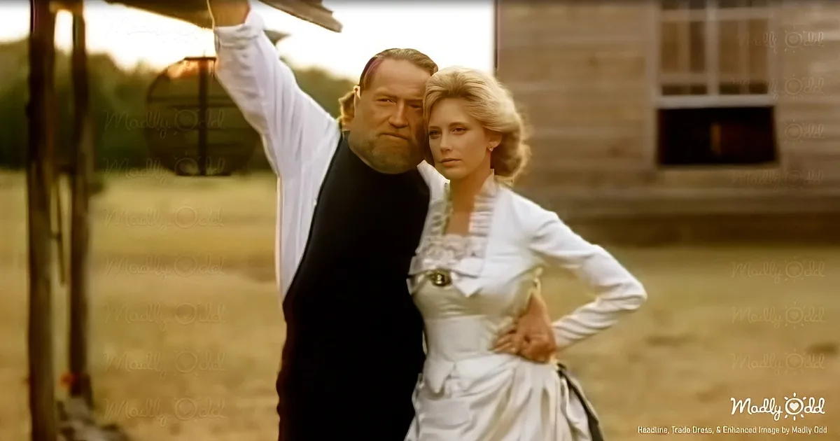 A man in a vest and a woman in a white dress stand together in a rural setting, with the man raising his arm.