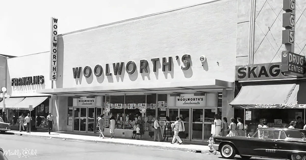 Woolworth's store facade with people walking, cars parked, and signs above.