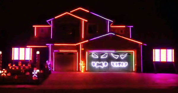 A house is adorned with vibrant neon lights in various colors, creating a festive and eye-catching display.