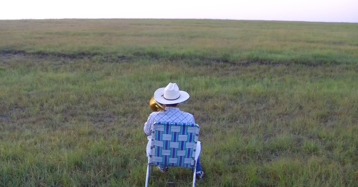 Farmer with trombone in the field, cows come running to the music