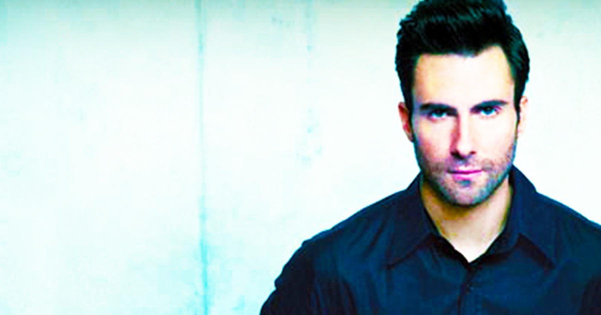 A man in a black shirt with a tattoo on his arm stands against a blue wall, text below mentions "Purple Rain" and chills.