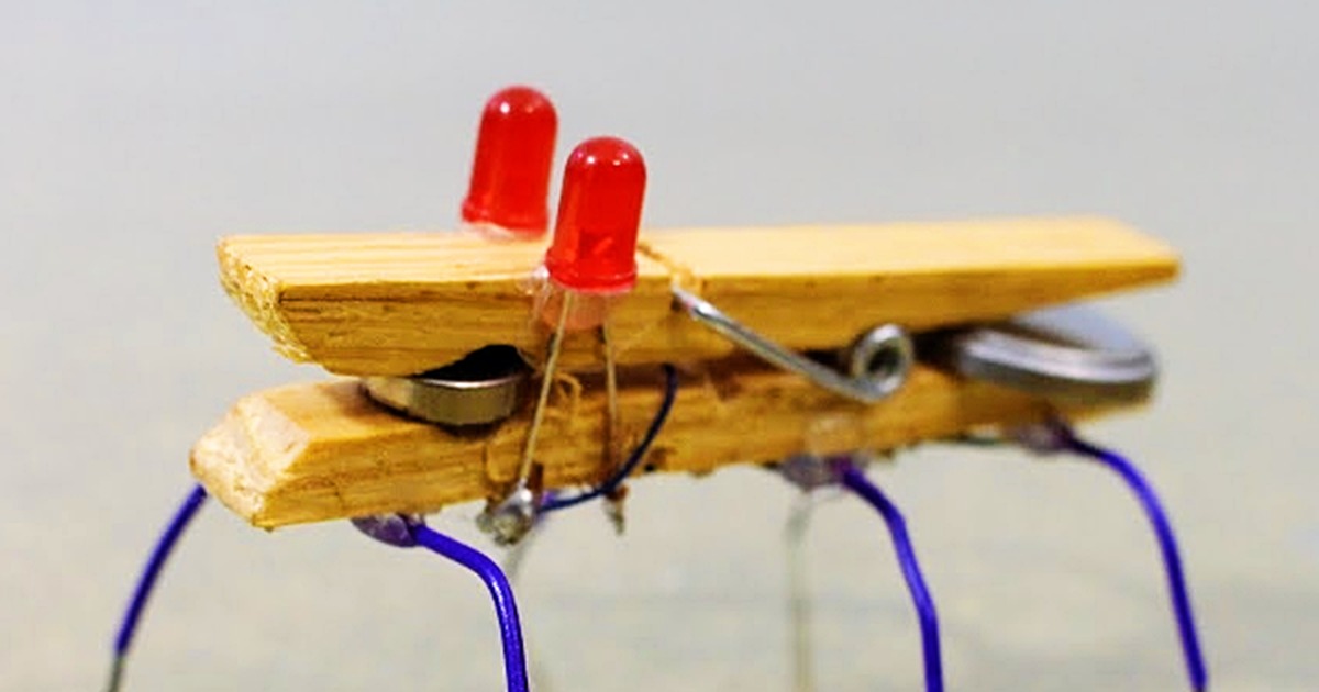A mini robotic bug made from common household items, featuring LED lights and a clothespin body.