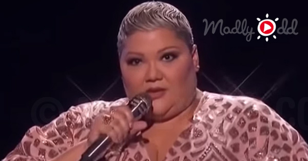 A woman in a sequined dress sings passionately into a microphone on stage.