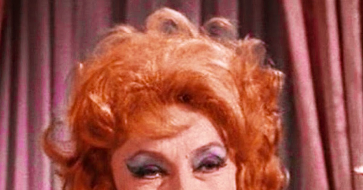 A woman with red hair and a green outfit is smiling, with a text overlay about grandmothers.