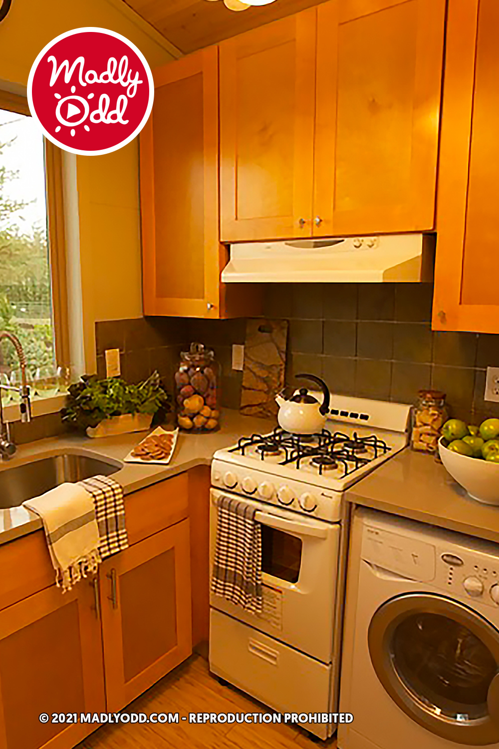 A cozy kitchen with wooden cabinets, a white stove, and a sink filled with fresh produce.