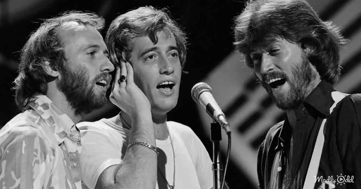 Three men singing, one holding hand to face, microphone in front, black-and-white image.